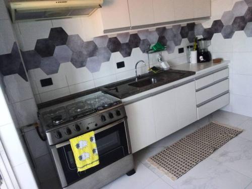 a kitchen with a stove and a sink at Apartamento aconchegante de montanha in São Roque