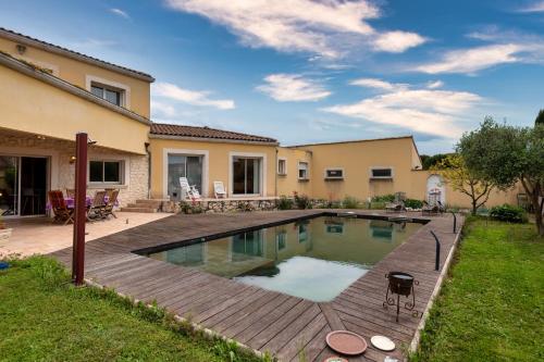 une piscine dans une cour à côté d'une maison dans l'établissement Les Sylphides - Maison avec piscine, à Montélimar