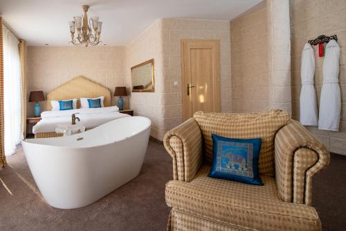 a bathroom with a tub and a bed and a bedroom at Hotel Azzun Orient SPA&Wellness in Kromerowo