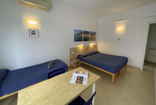 a room with a bed and a table and a couch at Residence Glicini in Finale Ligure