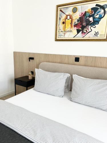 a bed with two pillows and a painting above it at Apartments Mrdak in Bar