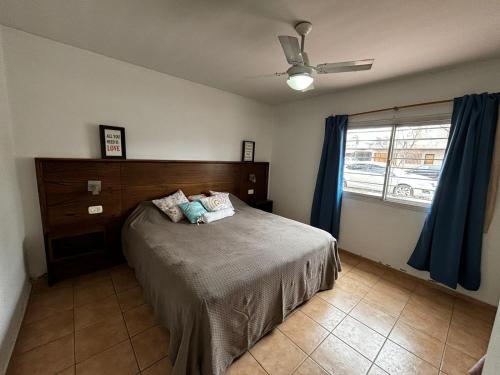 Un dormitorio con una cama y un ventilador de techo. en Departamento en pleno centro, a metros de todo !, en San Rafael