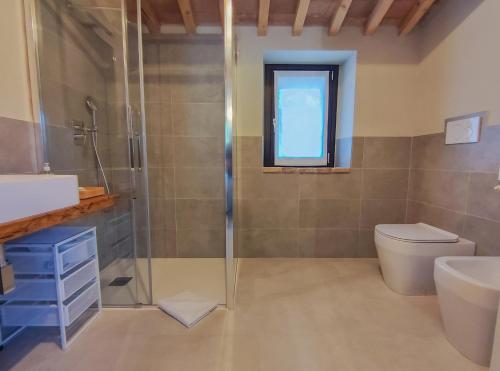 a bathroom with a shower and a toilet and a sink at La Fonte Delle Faranghe by Host Hero in Esanatoglia