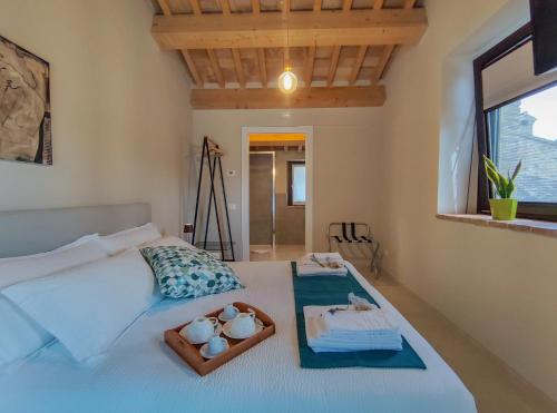 a bedroom with a bed with a tray of candles on it at La Fonte Delle Faranghe by Host Hero in Esanatoglia