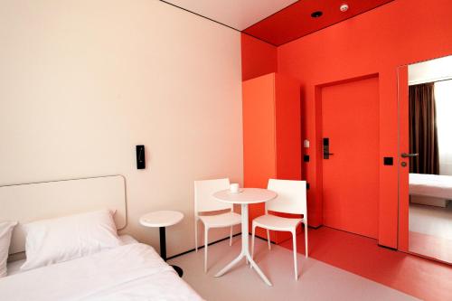 a bedroom with a bed and a table and chairs at Ultramarinn Hotel in Odesa