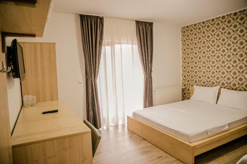 a bedroom with a bed and a window at Vila Rafael si Robert in 2 Mai
