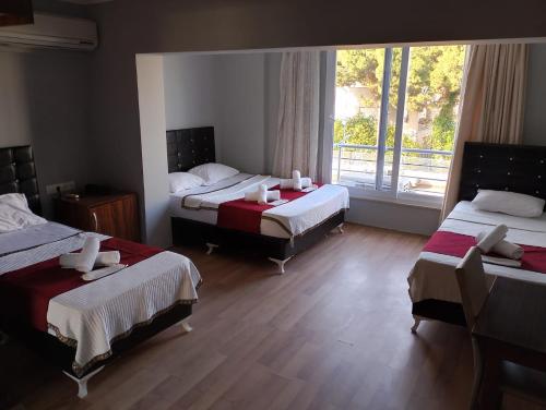 una camera d'albergo con due letti e una grande finestra di BALŞEN HOTEL a Anamur
