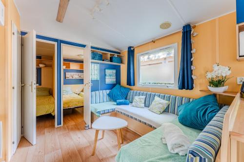 salon z kanapą i łóżkiem w obiekcie Mobil Home 304 Grand Confort w mieście Gastes