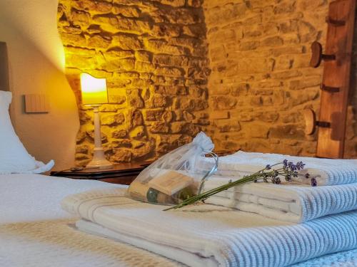 a bedroom with a bed with towels and a stone wall at La Fonte Delle Faranghe by Host Hero in Esanatoglia