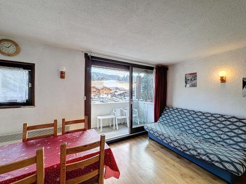 une chambre avec un lit, une table et une fenêtre dans l'établissement Soulane - appartement -4pers -centre, aux Gets