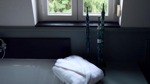 a room with a white towel laying on the floor next to a window at Maison Mouche in Beaumont-en-Auge