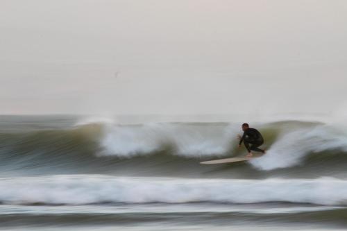 a man riding a wave on a surfboard in the ocean at Olas Surf Camp in Imsouane