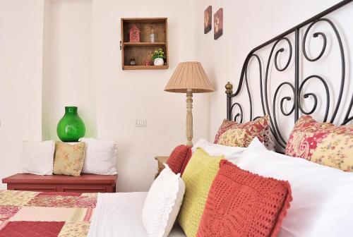 a bedroom with a large bed with colorful pillows at Case del Vicolo Stretto in Modica