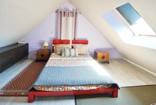 a attic bedroom with a bed and a window at Maison confortable à Férolles-Attilly avec jardin clos in Férolles-Attilly