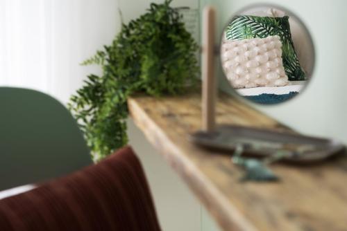 a mirror on top of a wooden table with a chair at 25trilocale Vista Mare e spiaggia Amazzonia style in Diano Marina
