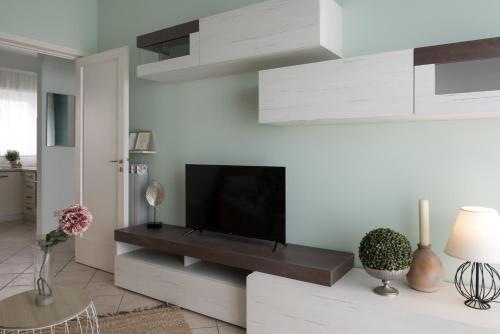 a living room with a flat screen tv on a wall at 25trilocale Vista Mare e spiaggia Amazzonia style in Diano Marina