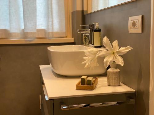a bathroom with a sink and a flower on a counter at Ca Marièt casa vacanze in Chiavenna