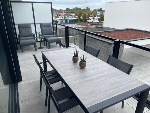 a wooden table and chairs on a balcony at Faro Greenpark, Cadzand-Bad APP 07 in Cadzand