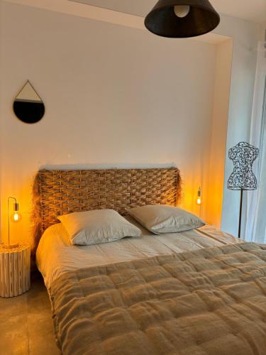 a bedroom with a large bed with a large headboard at Appartement cosy Quissac avec Jacuzzi in Quissac
