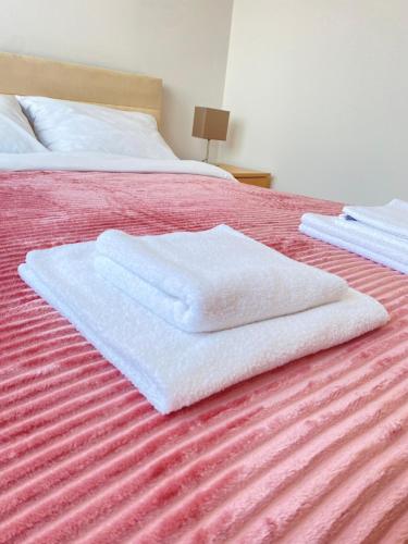 two white towels sitting on top of a bed at Light house in Sombor