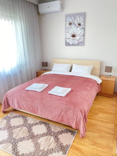 a bedroom with a large bed with two towels on it at Light house in Sombor