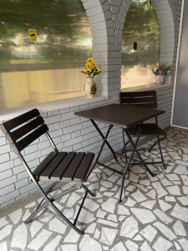 a table and two chairs sitting next to a table and a table at Light house in Sombor