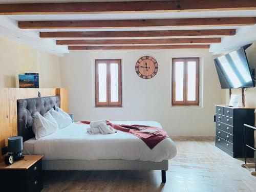 a bedroom with a bed and a clock on the wall at Domus Via Domitia in Narbonne