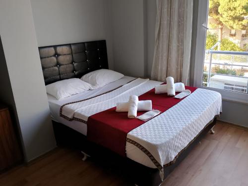 una camera da letto con un letto, asciugamani e una finestra di BALŞEN HOTEL a Anamur