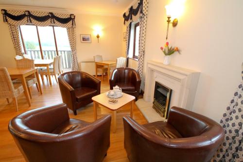 a living room with leather chairs and a fireplace at Llety Ceiro Guesthouse in Aberystwyth