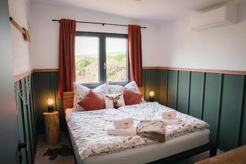 a bedroom with a bed with pillows and a window at Fisherman's Cabin in České Budějovice
