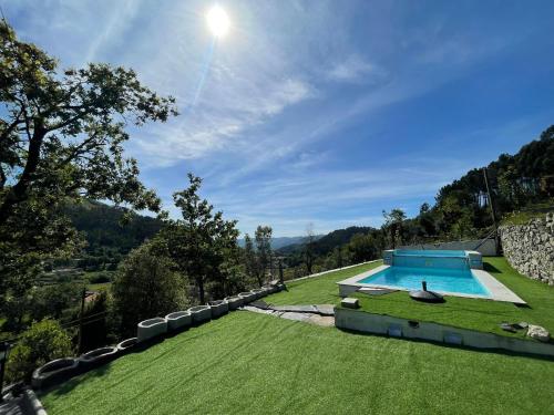an image of a swimming pool in a grass field at Casa d'Avó Lina - Gerês in Terras de Bouro