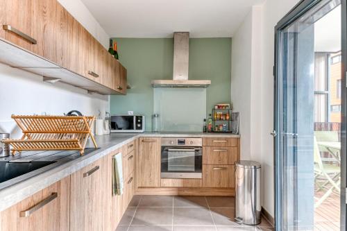 une cuisine avec des armoires en bois et une fenêtre dans l'établissement GuestReady - A lovely stay in Voltaire Part-Dieu, à Lyon