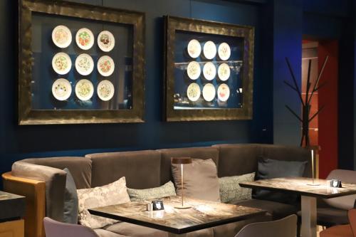 a restaurant with two tables and plates on the wall at Mondial Hotel in Tirana