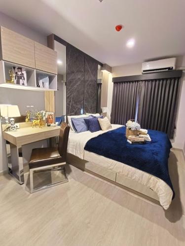 a bedroom with a bed and a desk with a blue blanket at DiamondHouse in Hat Yai