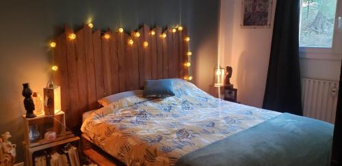 - une chambre avec un lit doté d'une tête de lit en bois et de lumières dans l'établissement Entre terre et mer, à Toulon