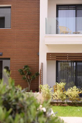 a house with a balcony with a chair on it at Falena Luxury Rooms in Kalyves Poligirou