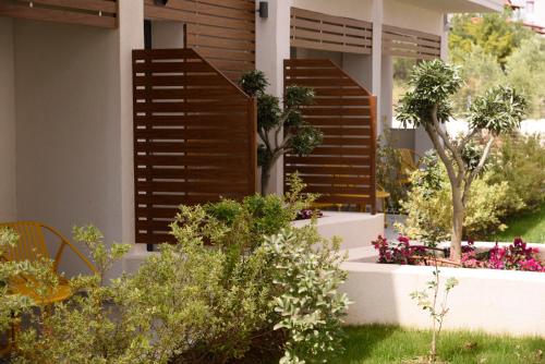 a garden with wooden shutters on a house at Falena Luxury Rooms in Kalyves Poligirou