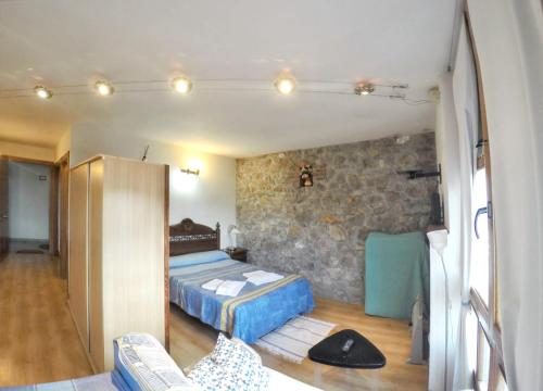 1 dormitorio con cama y pared de piedra en One bedroom apartement with furnished terrace and wifi at Llanes 3 km away from the beach, en Llanes
