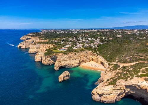 an island with rocks in the water and a beach at Casa Lucia (Terraços de Benagil 47) in Benagil