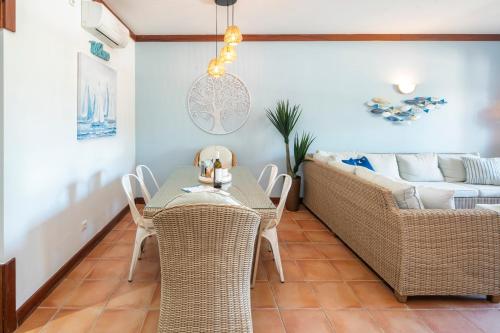 a living room with a table and chairs and a couch at Casa Lucia (Terraços de Benagil 47) in Benagil
