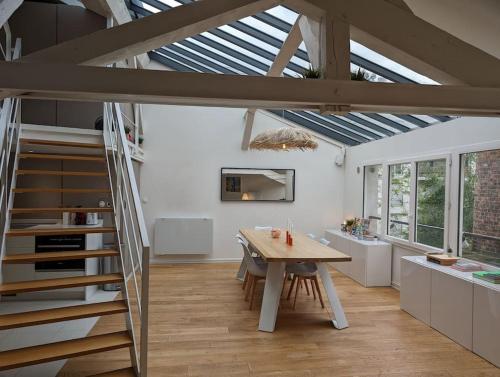 une cuisine et une salle à manger avec une table et une mezzanine dans l'établissement R'Apparts T3 Montreuil Sky Loft, à Montreuil