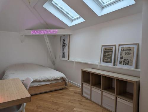 - une chambre avec un lit, un bureau et des lucarnes dans l'établissement R'Apparts T3 Montreuil Sky Loft, à Montreuil