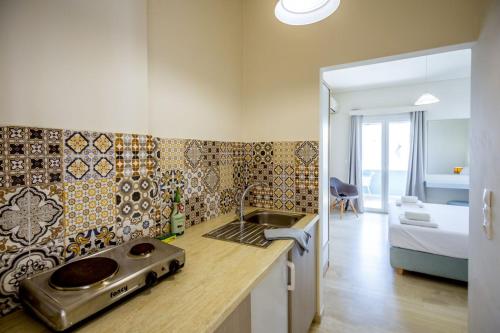 a kitchen with a sink and a bathroom with a bed at Blue Horizon Studios in Vasilikos