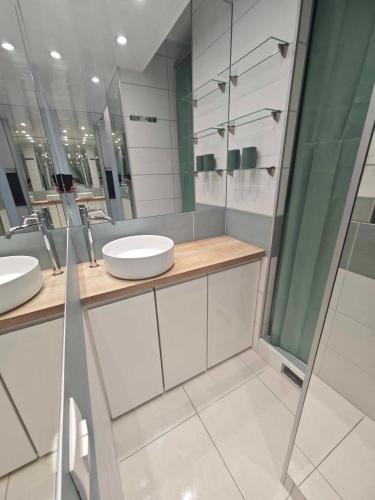 une salle de bain avec deux lavabos et une douche dans l'établissement Appartement Village Naturiste Tentation, au Cap d'Agde