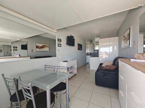 une cuisine et un salon avec une table et un canapé dans l'établissement Appartement Village Naturiste Tentation, au Cap d'Agde