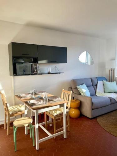 un salon avec une table et un canapé dans l'établissement Cosy T2 au coeur de Port-Grimaud dans le Golf de St Tropez, à Grimaud