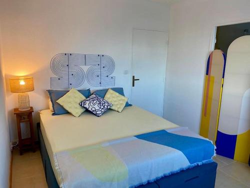 une chambre avec un lit avec des oreillers dessus dans l'établissement Cosy T2 au coeur de Port-Grimaud dans le Golf de St Tropez, à Grimaud