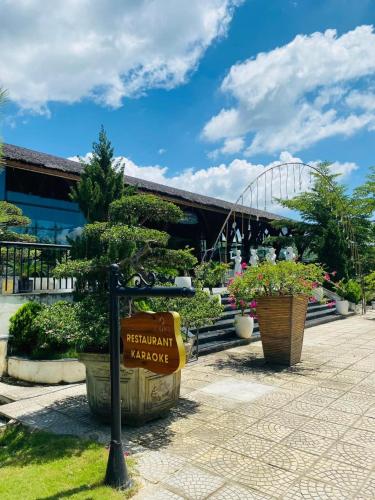 a sign in front of a building with a tree at Ivory Villas & Resort - Villa view hồ Lake View in Rống Vong