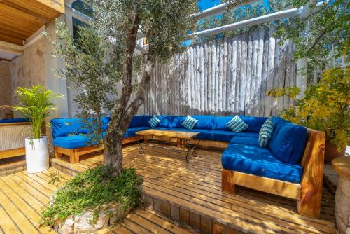 a blue couch on a wooden deck with a tree at Elixir Hotel in Kalkan