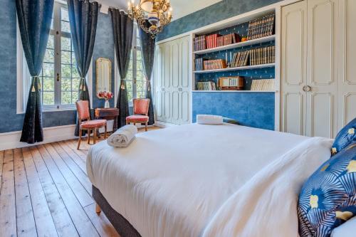 a bedroom with a large white bed and blue walls at Le Manoir de la belle epoque in Béthencourt-sur-Mer